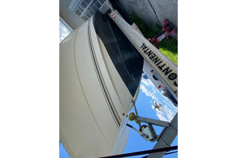 Slide: The Image of 2002 Wellcraft 290 Coastal boat on trailer, side view under clear sky. - 17
