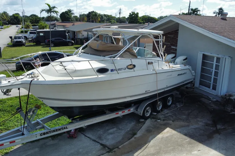 Slide: The Image of 2002 Wellcraft 290 Coastal boat on trailer beside a house in a residential area. - 2