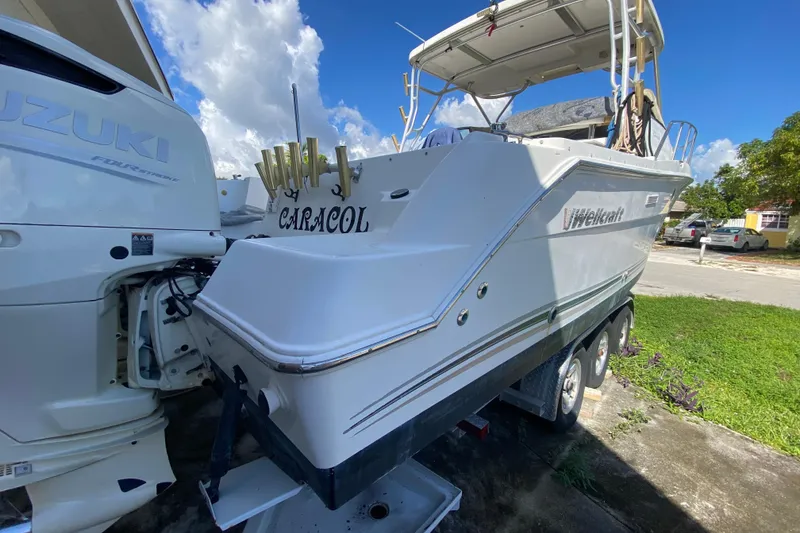 Slide: The Image of 2002 Wellcraft 290 Coastal boat on trailer, featuring Suzuki outboard engines. - 23