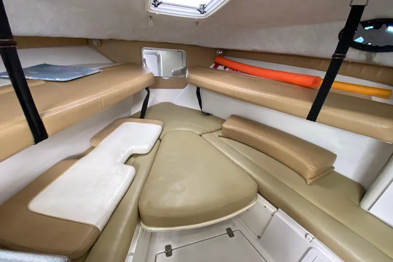 Slide: The Image of 2002 Wellcraft 290 Coastal cabin interior with beige seating and storage compartments. - 31