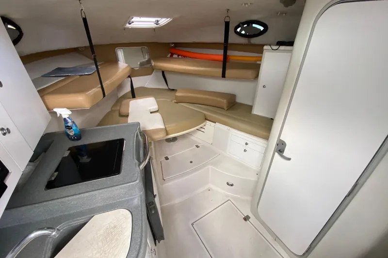 Slide: The Image of 2002 Wellcraft 290 Coastal cabin interior with seating, kitchenette, and storage. - 32