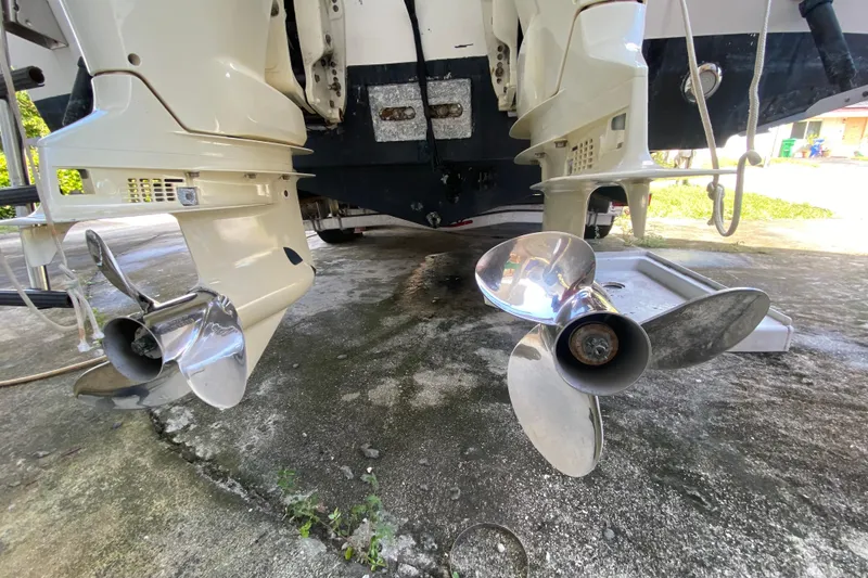 Slide: The Image of 2002 Wellcraft 290 Coastal boat propellers on concrete surface, showcasing dual outboard engines. - 39