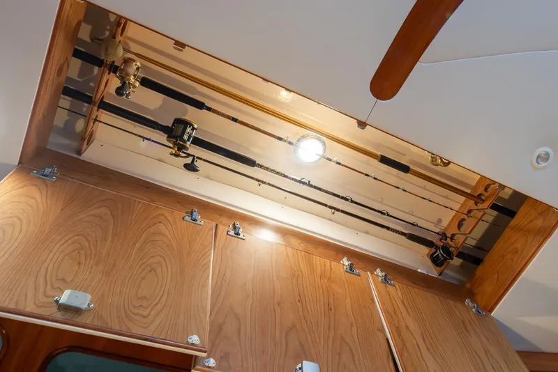 Slide: The Image of Ceiling rod storage on 2004 Mikelson 50 Sportfisher boat, featuring wooden cabinetry. - 11