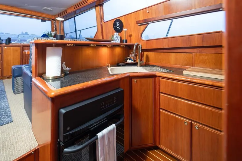Slide: The Image of Luxurious 2004 Mikelson 50 Sportfisher yacht interior with elegant wood cabinetry and modern amenities. - 14
