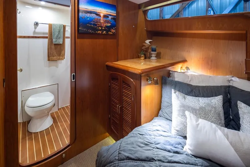 Slide: The Image of Luxurious cabin interior of 2004 Mikelson 50 Sportfisher with cozy bed and ensuite bathroom. - 21