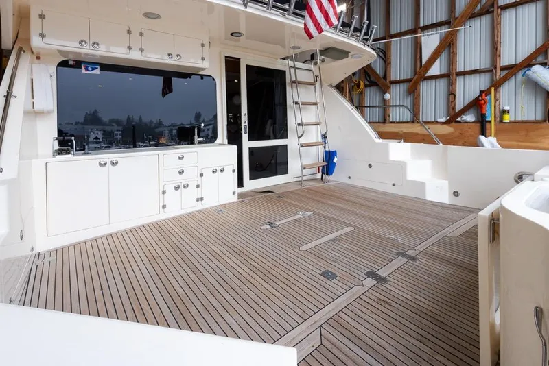 Slide: The Image of 2004 Mikelson 50 Sportfisher yacht deck with wood flooring and storage cabinets. - 37