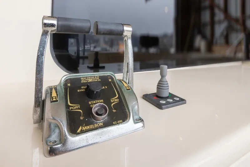 Slide: The Image of Control panel of a 2004 Mikelson 50 Sportfisher boat with throttle and joystick. - 41