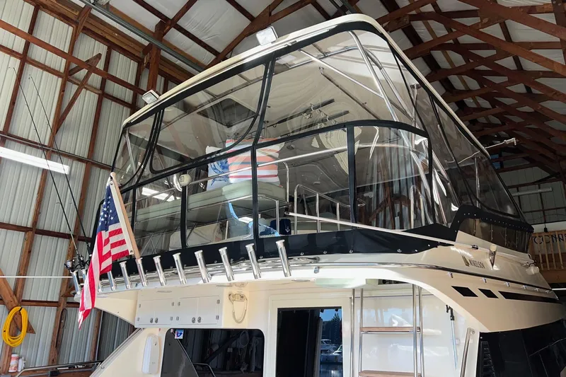 Slide: The Image of 2004 Mikelson 50 Sportfisher yacht in a boathouse with American flag. - 50
