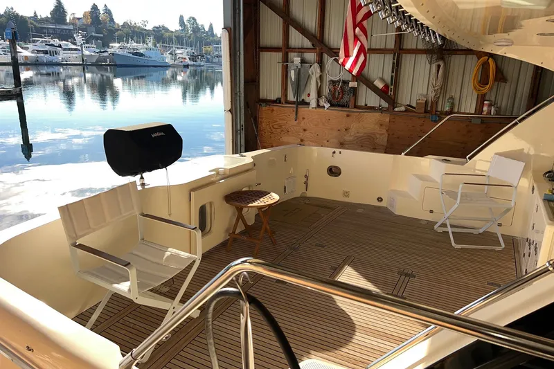 Slide: The Image of 2004 Mikelson 50 Sportfisher yacht deck with seating, docked in a marina. - 51