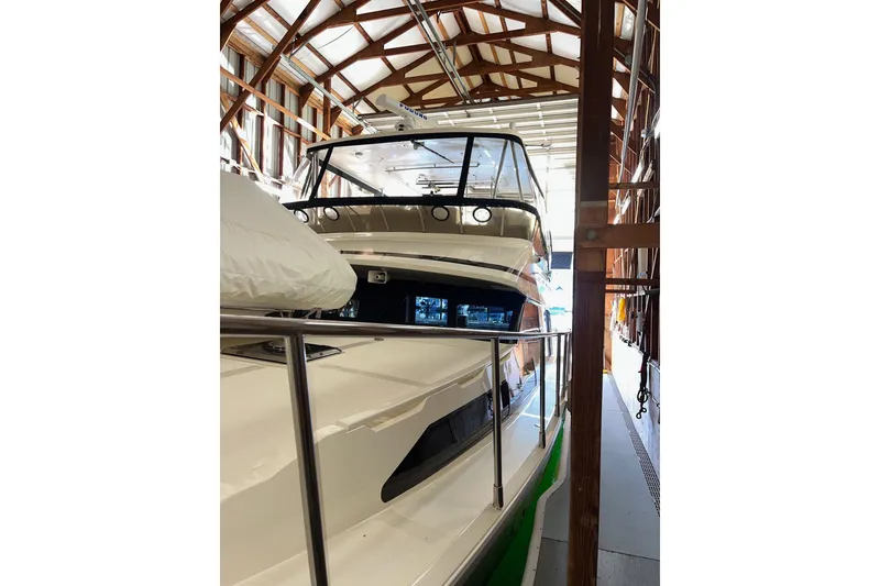 Slide: The Image of 2004 Mikelson 50 Sportfisher yacht docked in a wooden boathouse. - 52