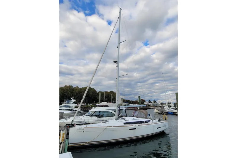 Slide: The Image of 2014 Jeanneau 379 sailboat docked at marina under cloudy sky. - 2