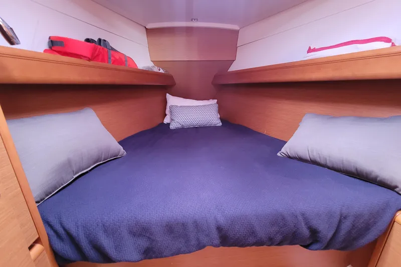 Slide: The Image of Cozy cabin interior of 2014 Jeanneau 379 sailboat with blue bedding and pillows. - 24