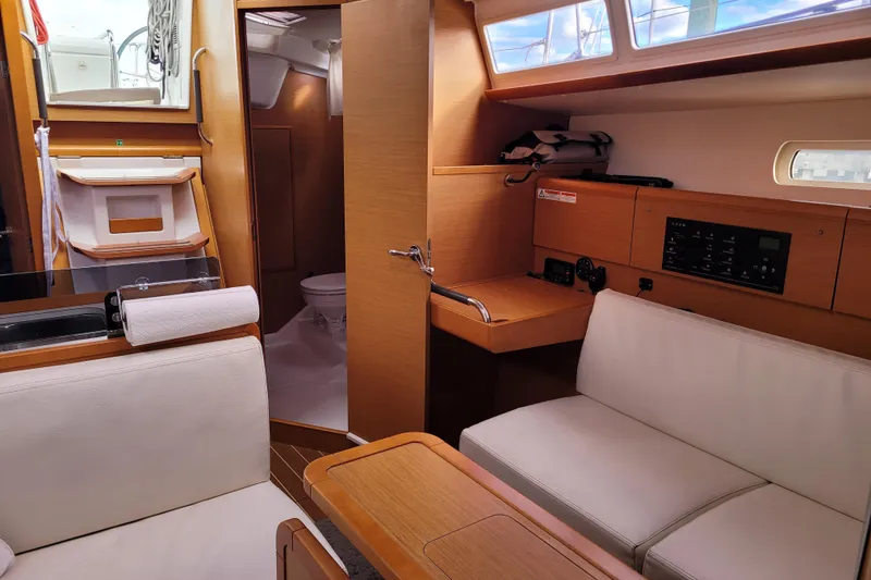 Slide: The Image of Interior of 2014 Jeanneau 379 sailboat with seating, table, and navigation panel. - 32