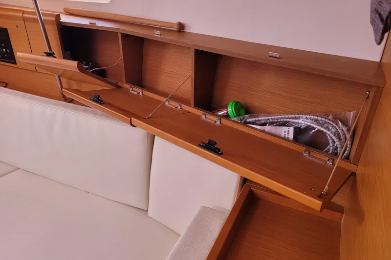 Slide: The Image of Interior storage compartments on a 2014 Jeanneau 379 sailboat, featuring wooden cabinetry and white seating. - 72