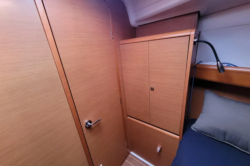 Slide: The Image of 2014 Jeanneau 379 interior cabin with wooden cabinetry and cozy bedding. - 26