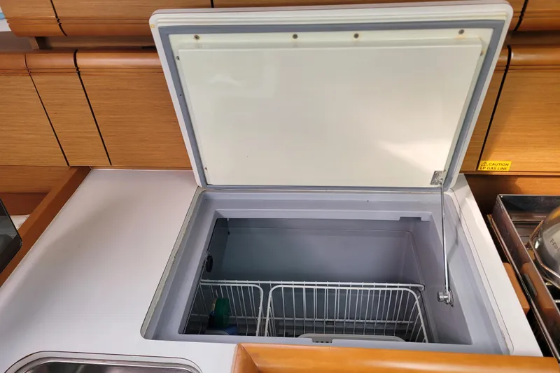 Slide: The Image of Open freezer compartment in 2014 Jeanneau 379 yacht kitchen, featuring wooden cabinetry. - 39