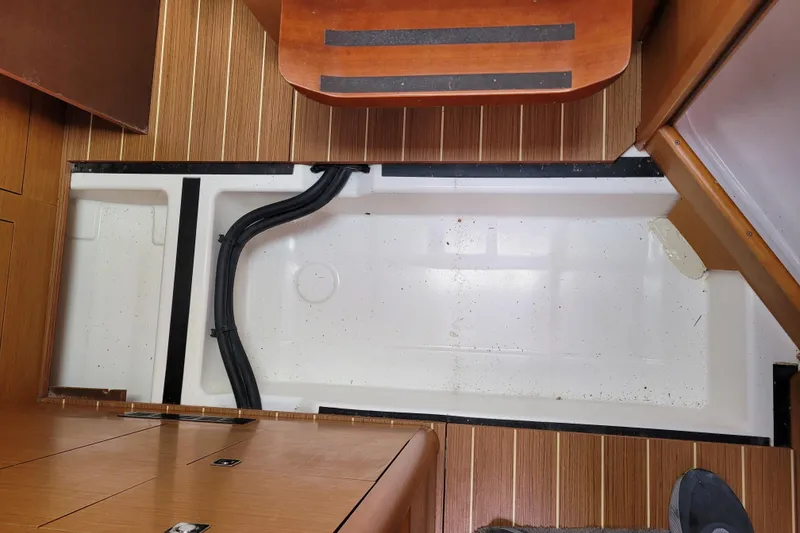Slide: The Image of Interior view of 2014 Jeanneau 379 sailboat, showcasing wooden flooring and storage compartment. - 67