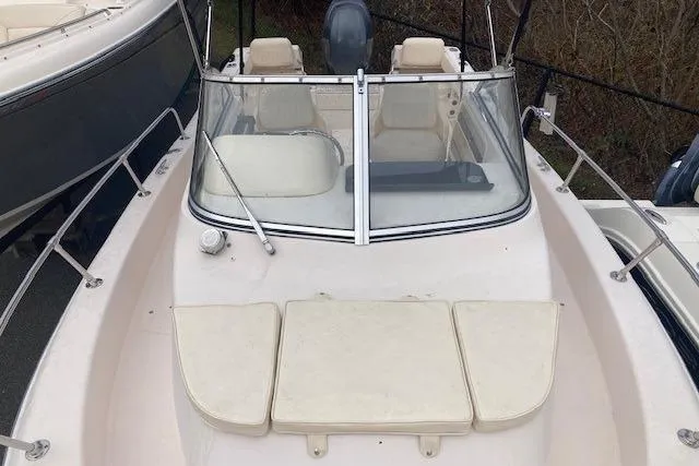 Slide: The Image of 2012 Grady-White Adventure 208 boat with beige seating and windshield, docked outdoors. - 11