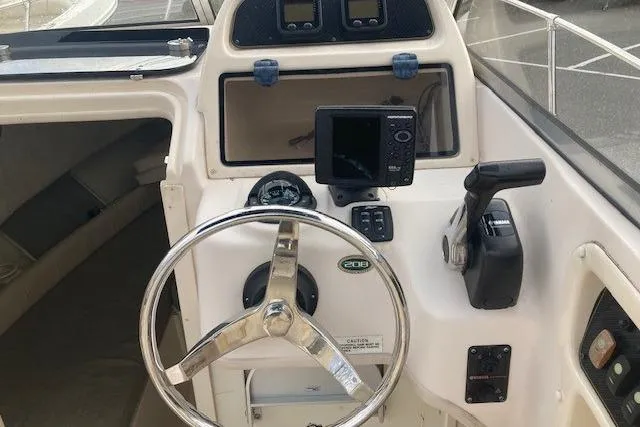 Slide: The Image of 2012 Grady-White Adventure 208 boat cockpit with steering wheel and navigation equipment. - 8