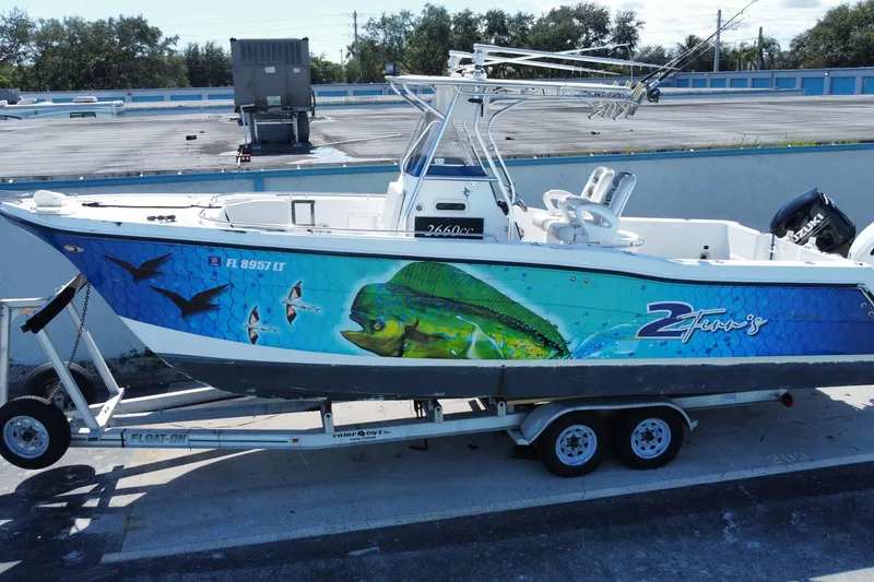 Slide: The Image of 2002 ProKat 2660 Center Console boat with vibrant marine graphics on a trailer. - 10