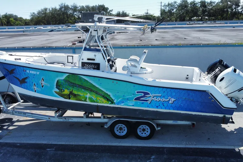 Slide: The Image of 2002 ProKat 2660 Center Console boat with vibrant fish artwork on trailer. - 11