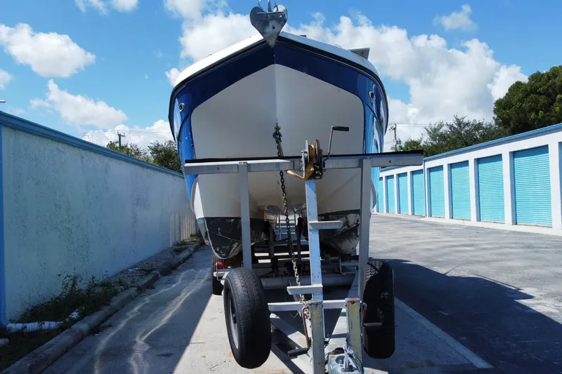 Slide: The Image of 2002 ProKat 2660 Center Console boat on trailer, parked near storage units. - 17