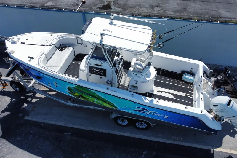 Slide: The Image of 2002 ProKat 2660 Center Console boat on trailer, featuring fishing rods and vibrant marine graphics. - 25