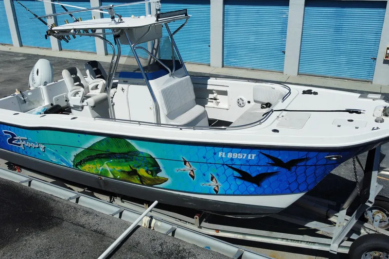 Slide: The Image of 2002 ProKat 2660 Center Console boat with vibrant marine graphics on trailer. - 30