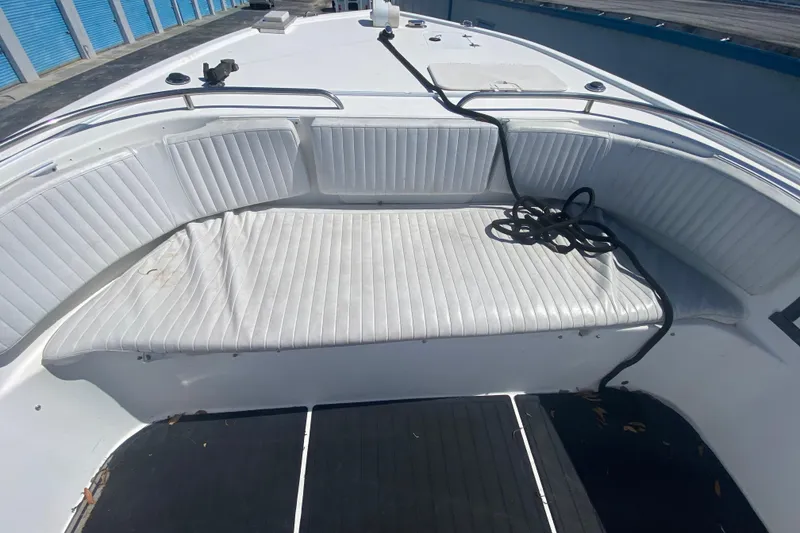 Slide: The Image of 2002 ProKat 2660 Center Console boat with white cushioned seating and coiled rope. - 32