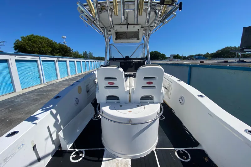 Slide: The Image of 2002 ProKat 2660 Center Console boat with dual seats and storage, docked under clear skies. - 37