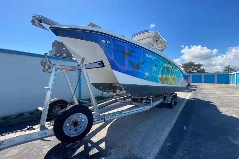 Slide: The Image of 2002 ProKat 2660 Center Console boat on trailer under clear blue sky. - 4