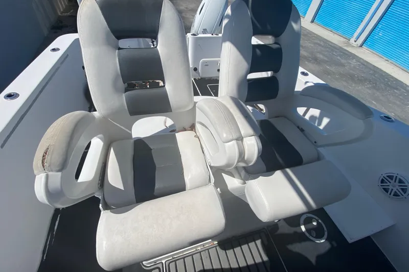 Slide: The Image of 2002 ProKat 2660 Center Console boat seats, white and gray, in outdoor storage. - 41