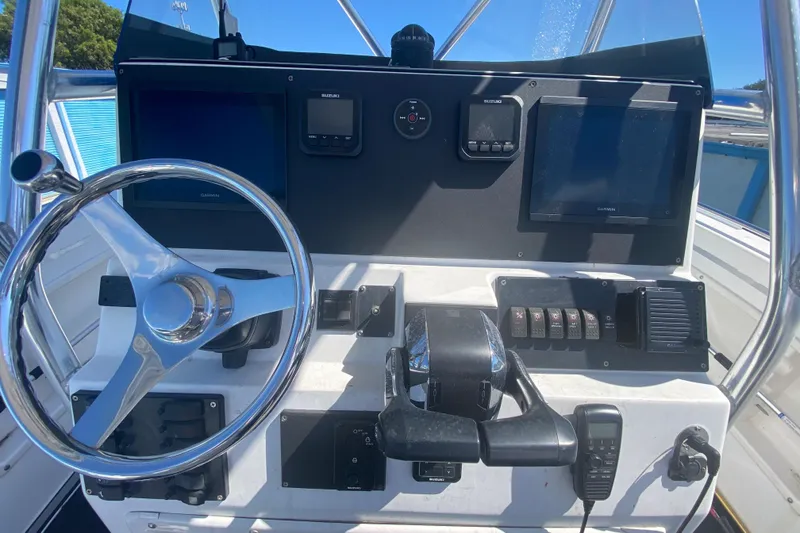 Slide: The Image of 2002 ProKat 2660 Center Console boat dashboard with steering wheel and navigation controls. - 43