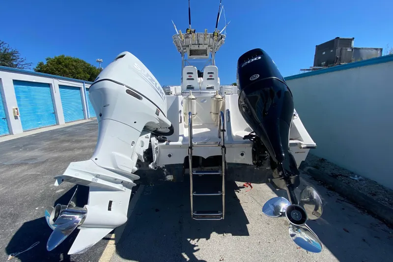 Slide: The Image of 2002 ProKat 2660 Center Console boat with dual outboard engines in storage facility. - 49