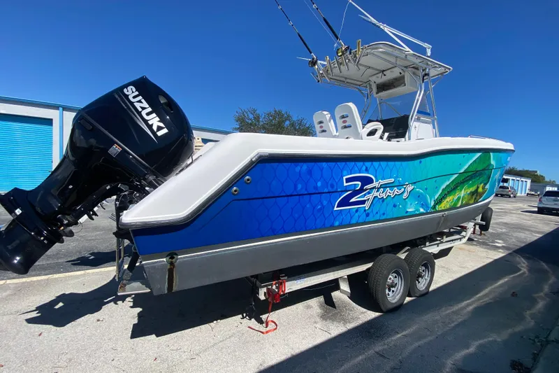 Slide: The Image of 2002 ProKat 2660 Center Console boat with Suzuki engine on trailer, vibrant blue design. - 5