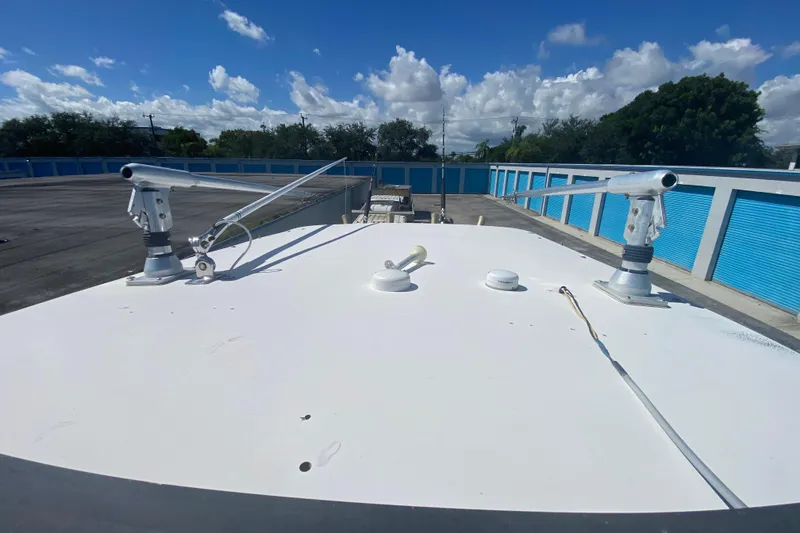 Slide: The Image of 2002 ProKat 2660 Center Console boat roof with antennas, under a clear blue sky. - 55