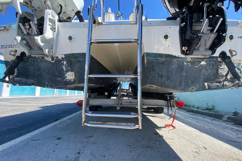 Slide: The Image of 2002 ProKat 2660 Center Console boat on trailer, rear view with ladder and engines. - 56