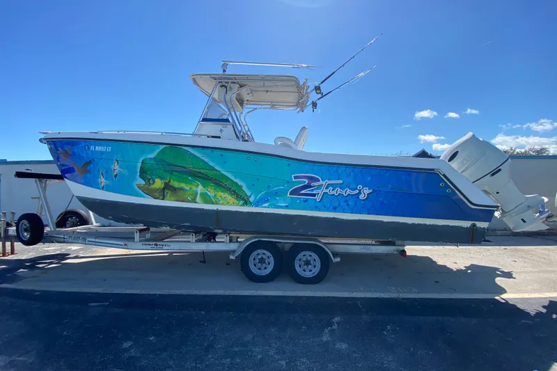 Slide: The Image of 2002 ProKat 2660 Center Console boat with vibrant marine-themed graphics on a trailer. - 6