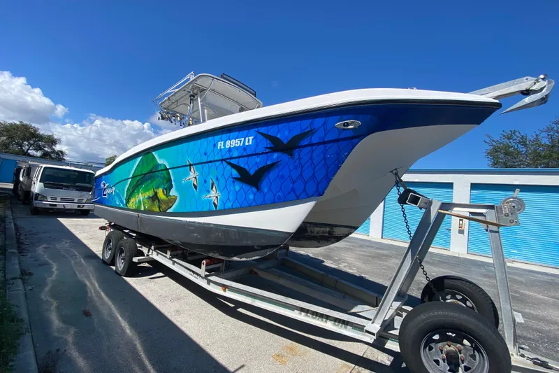 Slide: The Image of 2002 ProKat 2660 Center Console boat on trailer with vibrant marine-themed graphics. - 60