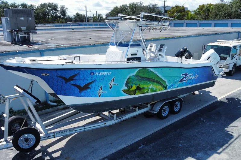 Slide: The Image of 2002 ProKat 2660 Center Console boat with vibrant fish artwork on trailer. - 9