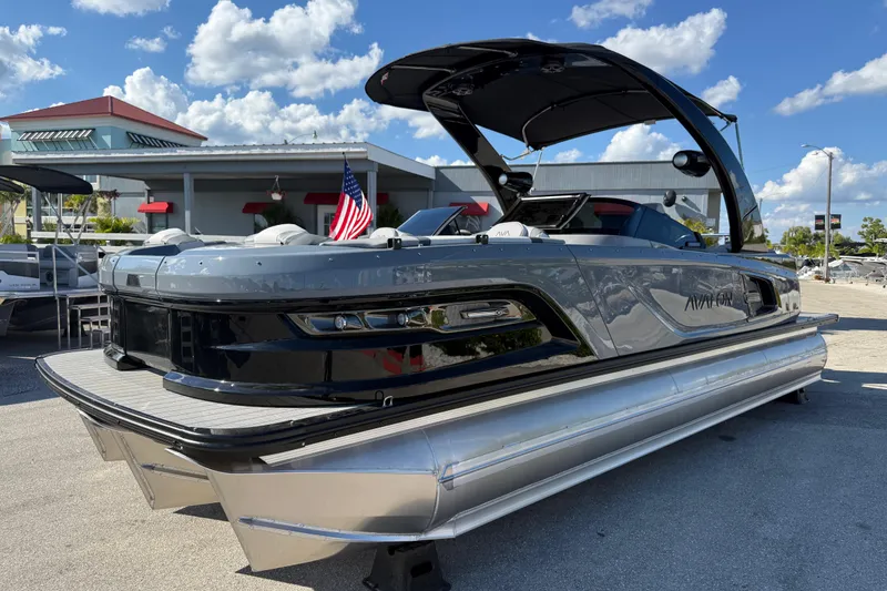 The Image of 2026 Avalon 2585 Excalibur pontoon boat with Mercury 400hp V-10 engine, docked under blue sky. - 1