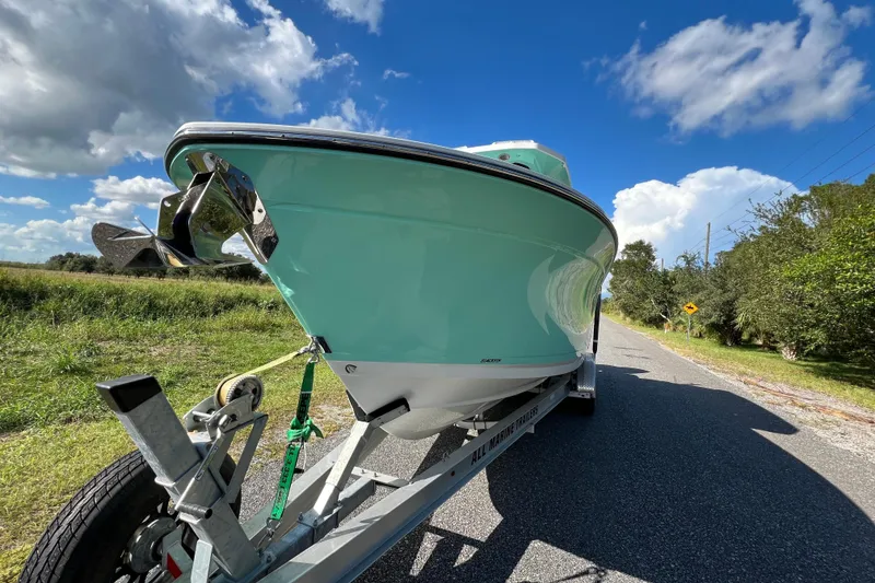 Slide: The Image of 2023 Blackfin 272 boat on trailer, parked on a rural road under a blue sky. - 27