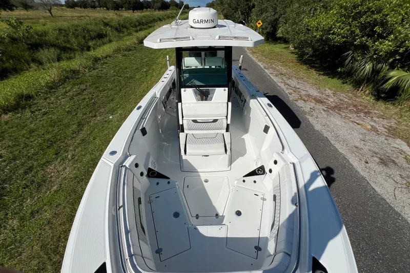 Slide: The Image of 2023 Blackfin 272 boat with Garmin equipment, parked on a roadside, surrounded by greenery. - 29