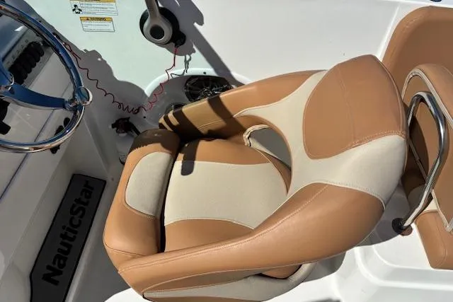 Slide: The Image of Captain's seat on 2016 NauticStar 223 DC boat, featuring tan and cream upholstery. - 14