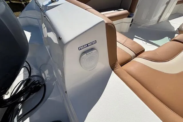 Slide: The Image of 2016 NauticStar 223 DC boat interior with fresh water access and tan seating. - 21