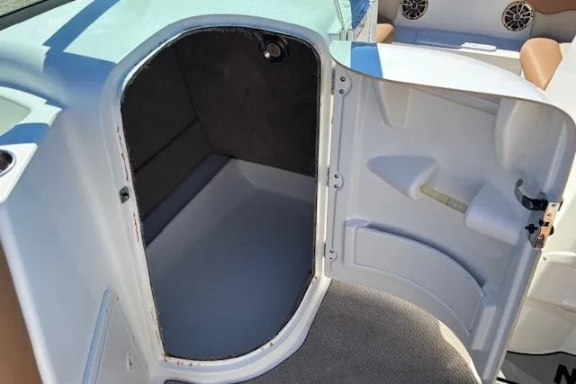 Slide: The Image of 2016 NauticStar 223 DC boat storage compartment with open door. - 33