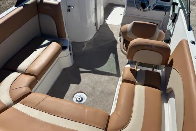 Slide: The Image of 2016 NauticStar 223 DC boat interior with tan seating and steering console. - 34