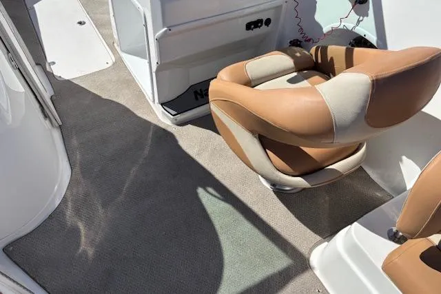 Slide: The Image of 2016 NauticStar 223 DC boat interior with tan leather seats and carpeted flooring. - 35