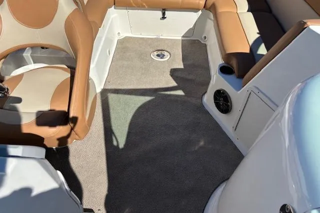 Slide: The Image of 2016 NauticStar 223 DC boat interior with tan seating and carpeted floor. - 36