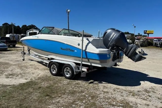 Slide: The Image of 2016 NauticStar 223 DC boat on trailer with Yamaha outboard motor, parked outdoors. - 7